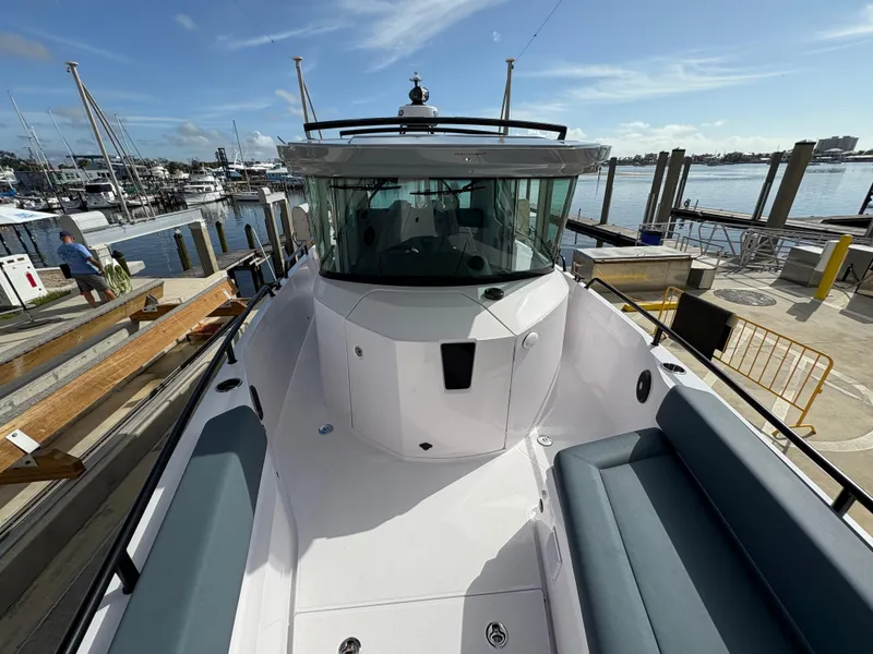 Slide: The Image of 2023 Axopar 28 AFT CABIN boat docked at marina under clear sky. - 14