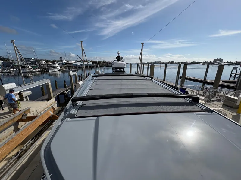 Slide: The Image of 2023 Axopar 28 AFT CABIN docked at a marina under a clear blue sky. - 15