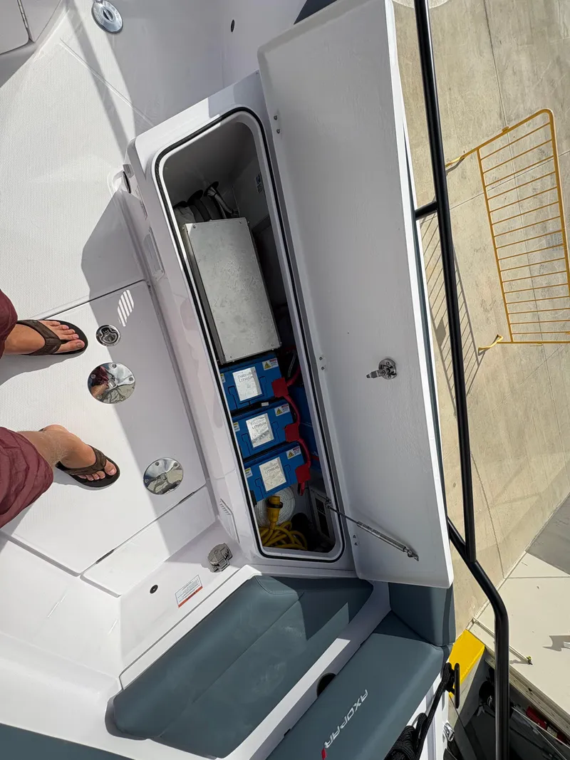 Slide: The Image of 2023 Axopar 28 AFT CABIN storage compartment with equipment and supplies. - 19