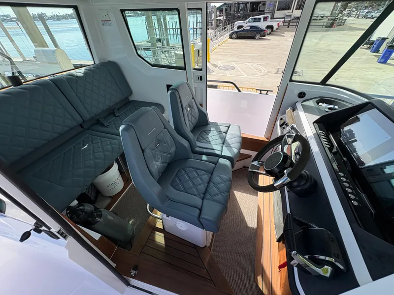 Slide: The Image of 2023 Axopar 28 AFT CABIN interior with modern seating and steering console. - 20