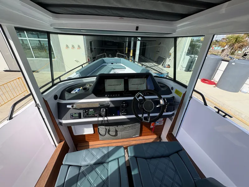 Slide: The Image of 2023 Axopar 28 AFT CABIN interior with modern dashboard and steering wheel. - 22