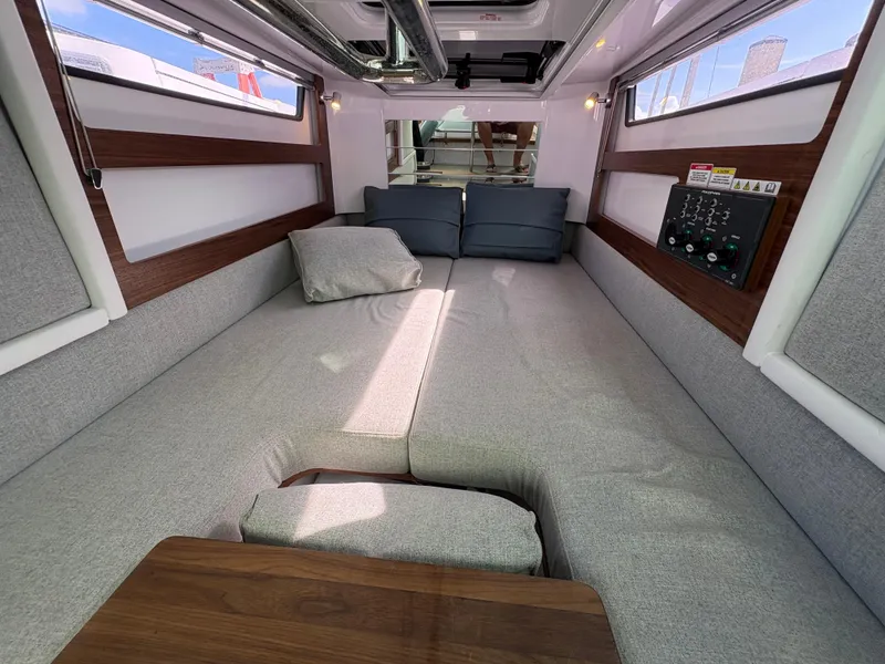 Slide: The Image of 2023 Axopar 28 AFT CABIN interior with gray seating and wooden accents. - 26