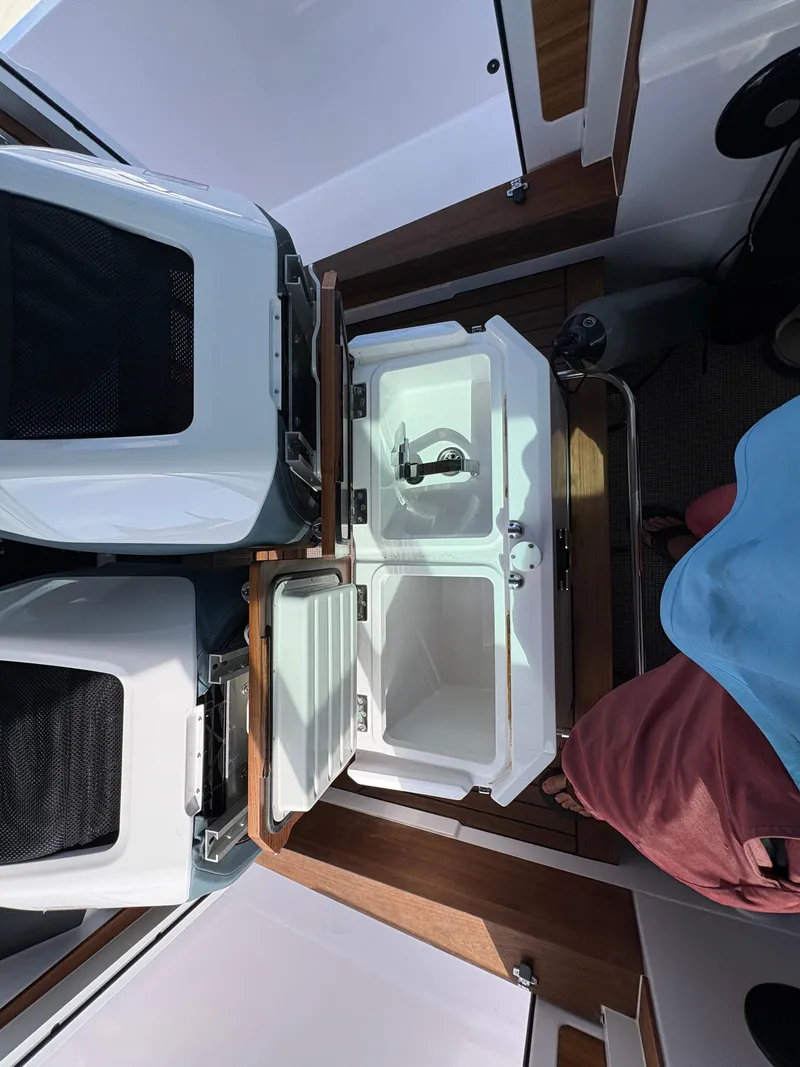 Slide: The Image of 2023 Axopar 28 AFT CABIN interior with open storage compartments. - 28