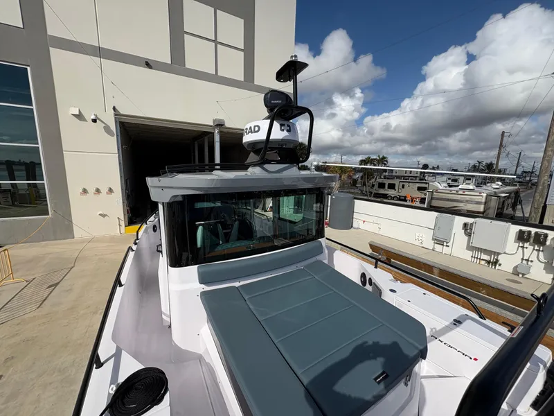Slide: The Image of 2023 Axopar 28 AFT CABIN boat docked near industrial building under cloudy sky. - 8