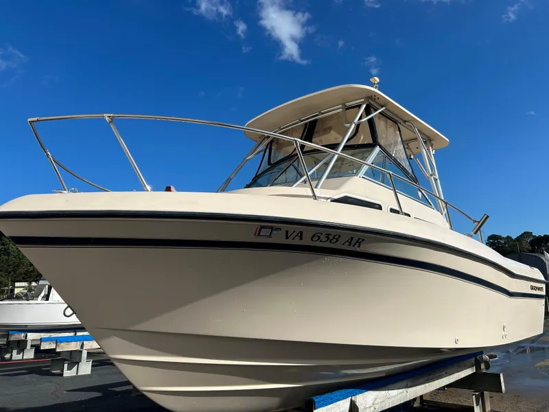 Slide: The Image of 1997 Grady-White 232 Gulfstream boat on display under a clear blue sky. - 1