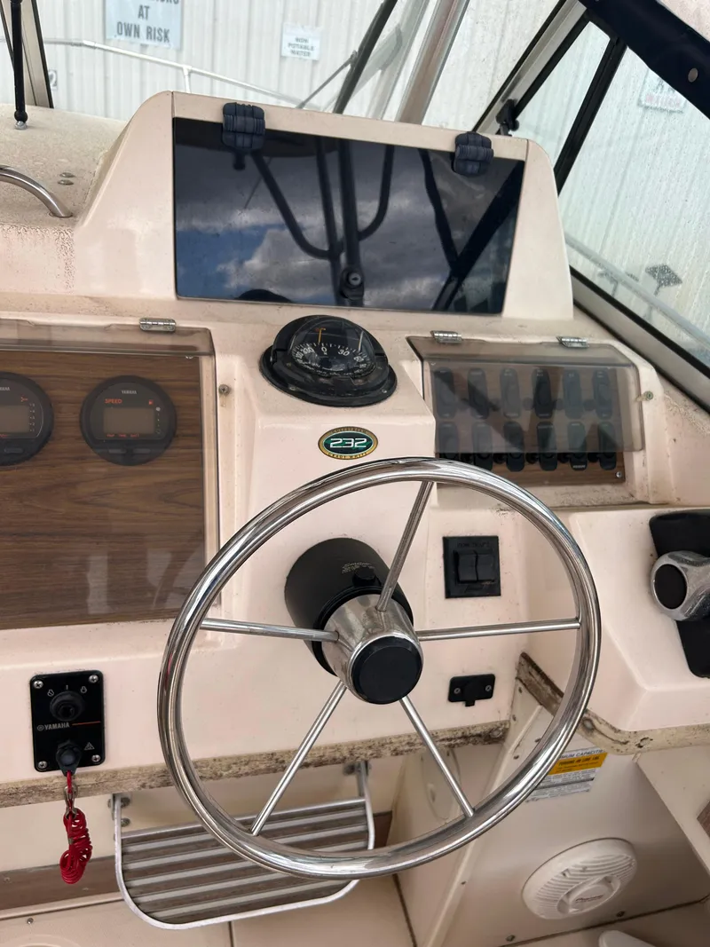 Slide: The Image of 1997 Grady-White 232 Gulfstream boat dashboard with steering wheel and instrument panel. - 13