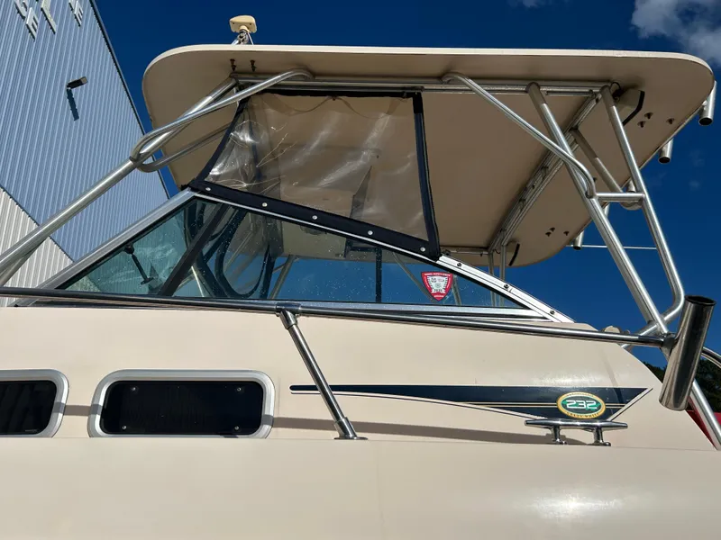 Slide: The Image of 1997 Grady-White 232 Gulfstream boat with canopy, viewed from the side. - 6