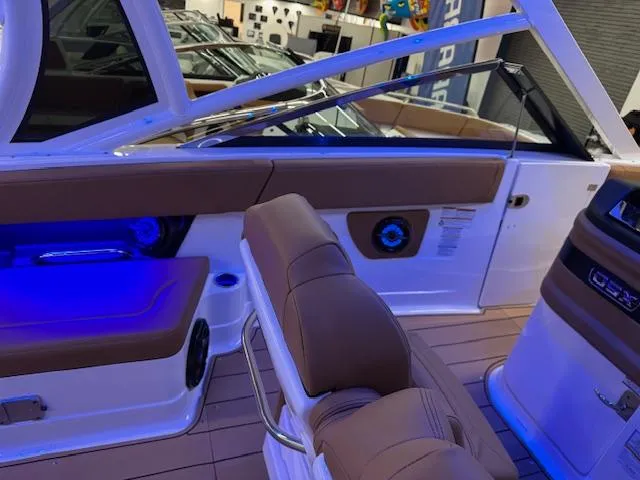 Slide: The Image of 2025 Chaparral 280 OSX boat interior with blue LED lighting and tan seating. - 14