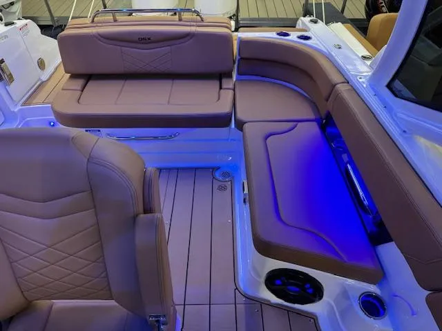 Slide: The Image of 2025 Chaparral 280 OSX boat interior with tan seating and blue LED lighting. - 16