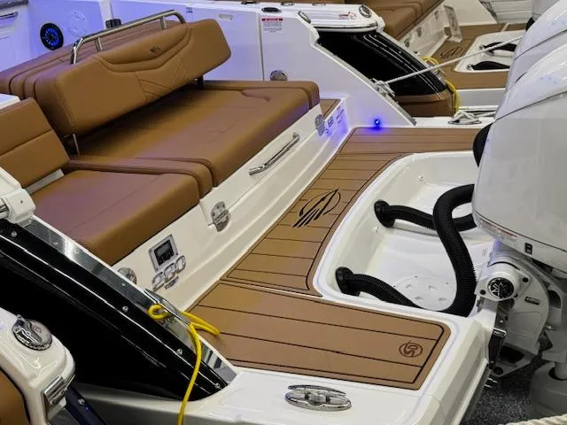 Slide: The Image of 2025 Chaparral 280 OSX boat interior with brown seating and modern design. - 25