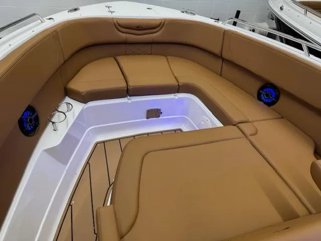 Slide: The Image of 2025 Chaparral 280 OSX boat interior with tan seating and blue speakers. - 4