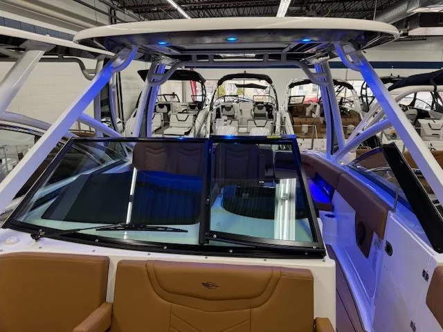 Slide: The Image of 2025 Chaparral 280 OSX boat interior with blue LED lighting in showroom. - 7