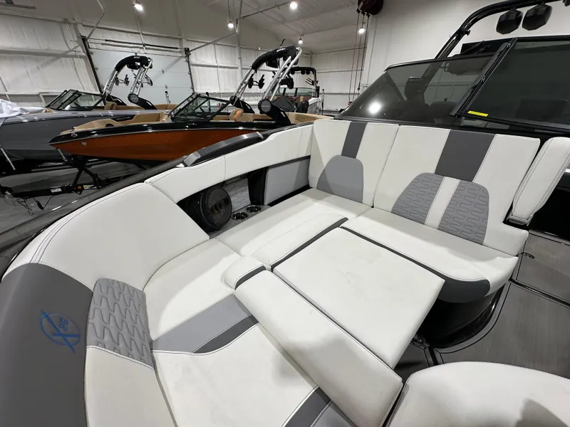 Slide: The Image of 2024 MasterCraft X26 boat interior with luxurious seating in a showroom. - 21