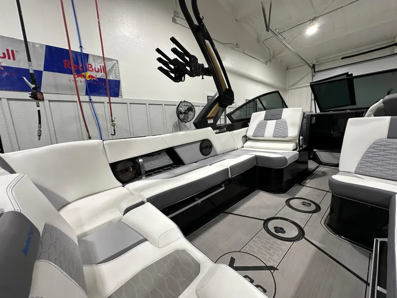 Slide: The Image of 2024 MasterCraft X26 boat interior with white and gray seating in a garage setting. - 9