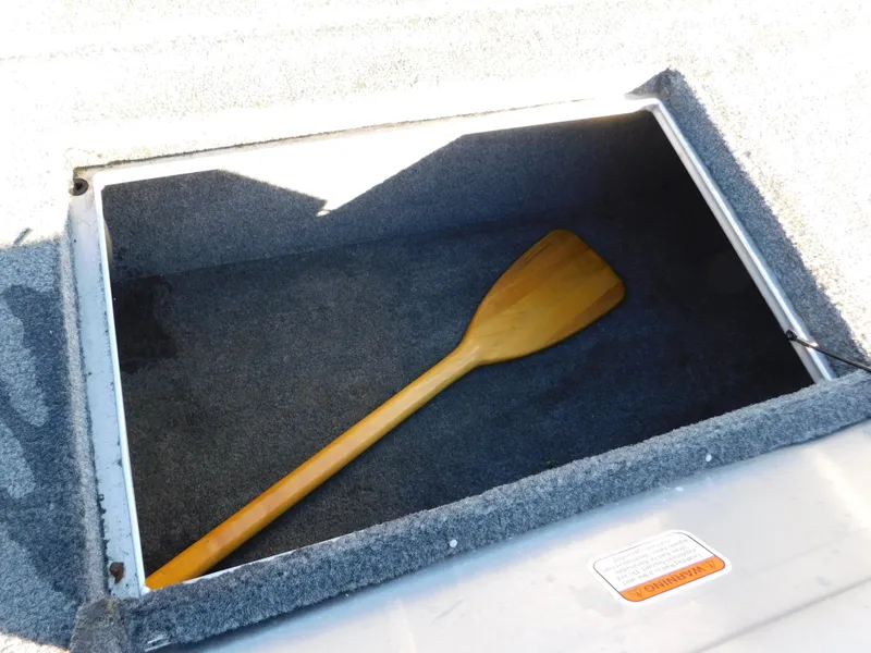 Slide: The Image of Storage compartment with wooden paddle in 2015 Tracker Pro Team 190 TX boat. - 28