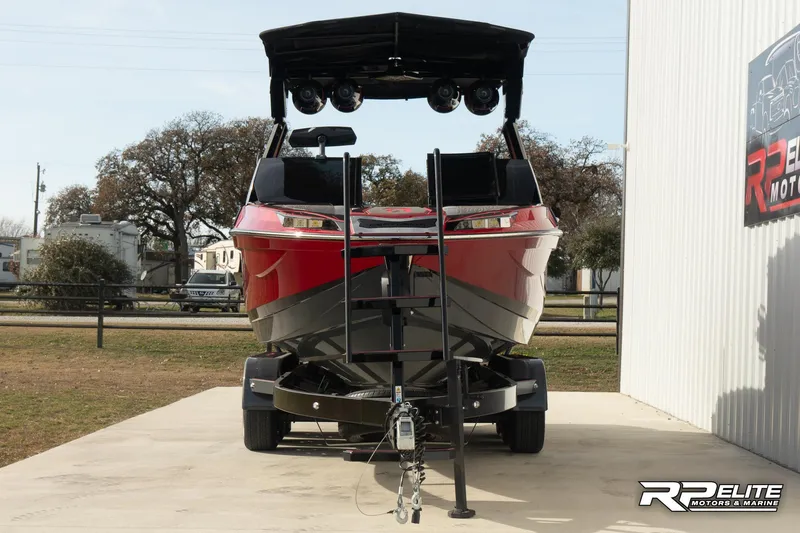 Slide: The Image of 2024 Centurion Ri245 boat on trailer, red and black, parked outdoors. - 11