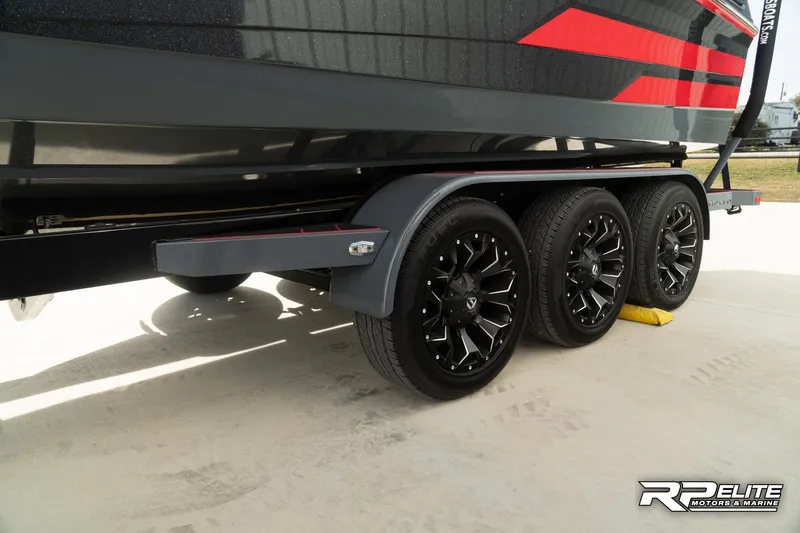 Slide: The Image of 2024 Centurion Ri245 boat trailer with black wheels and red accents. - 31