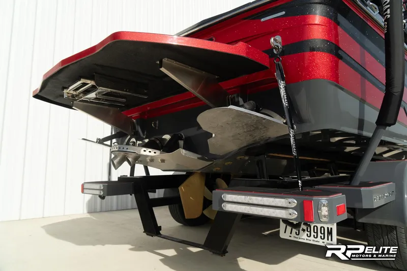 Slide: The Image of 2024 Centurion Ri245 boat rear view with trailer, featuring sleek red and black design. - 39