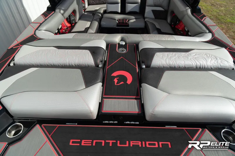 Slide: The Image of 2024 Centurion Ri245 boat interior with sleek gray and black seating, red accents, and logo detailing. - 48