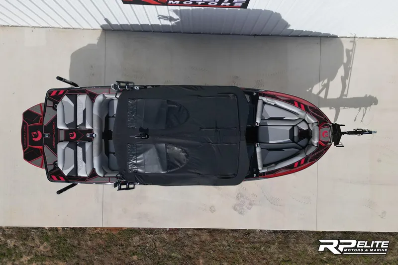 Slide: The Image of 2024 Centurion Ri245 boat, aerial view, black and red design, parked on concrete. - 8