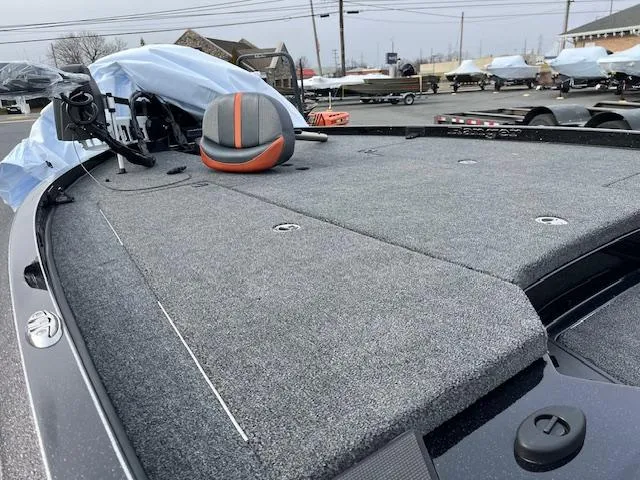 Slide: The Image of 2025 Ranger Z520 boat deck with gray carpeting and equipment, parked outdoors. - 10