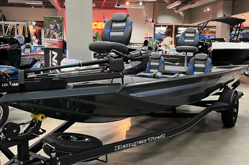 Slide: The Image of 2025 Ranger RT178 fishing boat displayed indoors with blue-accented seats. - 0