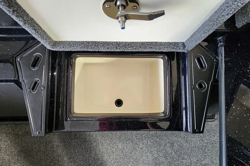 Slide: The Image of Ranger Z185 2025 boat compartment with latch, carpeted interior, and drainage hole. - 5