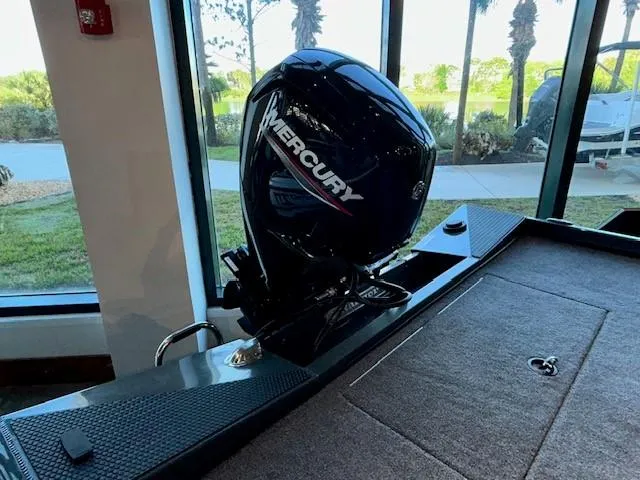 Slide: The Image of 2025 Ranger RT178 boat with Mercury outboard motor, displayed indoors near large windows. - 4