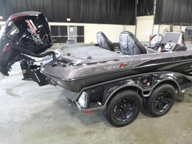 Slide: The Image of 2025 Ranger Z520 boat with dual axles and powerful outboard motor in an indoor setting. - 7