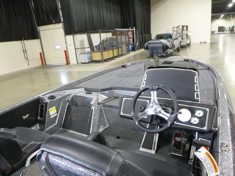 Slide: The Image of 2025 Ranger Z520 boat interior with steering wheel, dashboard, and seating in a warehouse setting. - 9