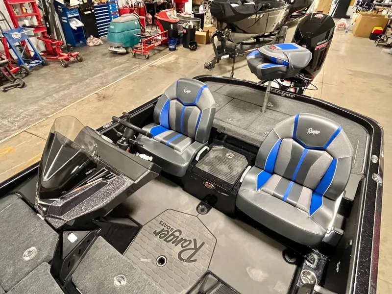Slide: The Image of 2025 Ranger Z520 boat interior with blue and gray seating in a workshop setting. - 11