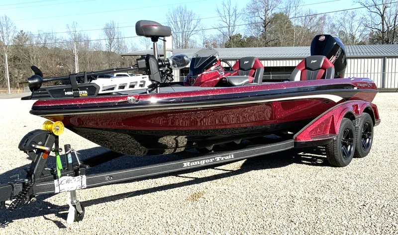 Slide: The Image of 2025 Ranger Z520 boat on trailer, parked outdoors, red and black design. - 2