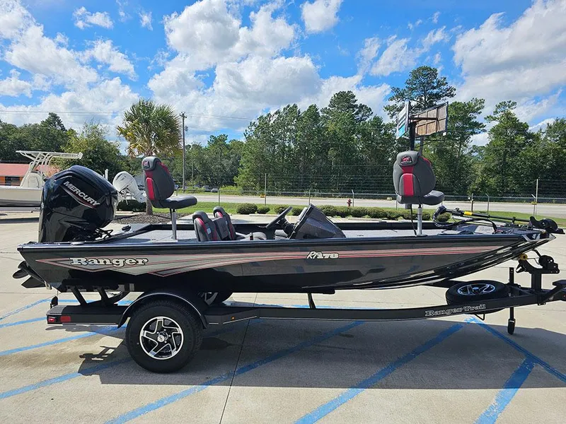Slide: The Image of 2025 Ranger RT178 fishing boat on trailer, parked outdoors under a blue sky. - 6