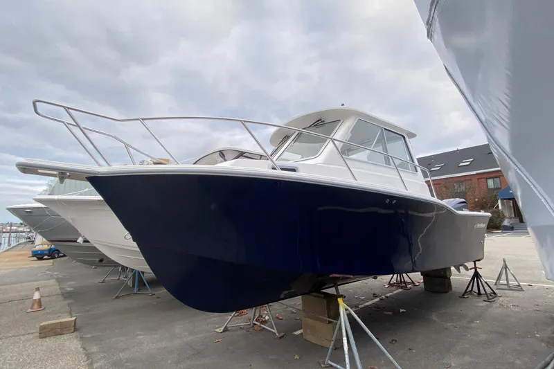 Slide: The Image of 2025 NorthCoast 235 HT boat on dry dock, blue hull, overcast sky. - 0
