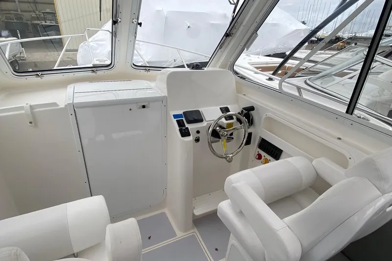 Slide: The Image of Interior of 2025 NorthCoast 235 HT boat, featuring helm station and seating. - 12