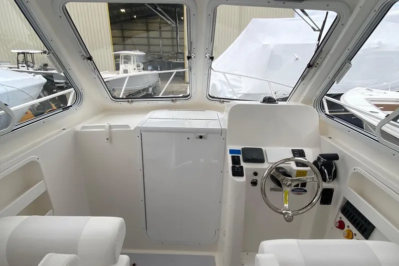 Slide: The Image of Interior of 2025 NorthCoast 235 HT boat, featuring helm and seating area. - 13