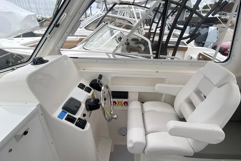 Slide: The Image of Interior of 2025 NorthCoast 235 HT boat with steering wheel and captain's chair. - 14