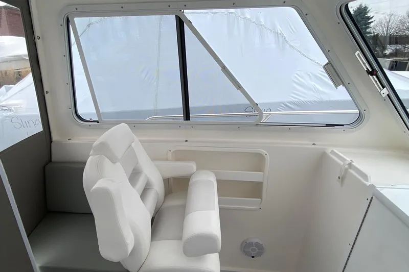 Slide: The Image of Interior of 2025 NorthCoast 235 HT boat with white seating and large windows. - 15
