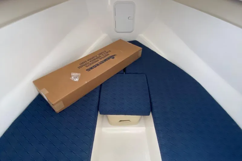 Slide: The Image of Interior of 2025 NorthCoast 235 HT boat with blue flooring and storage box. - 17