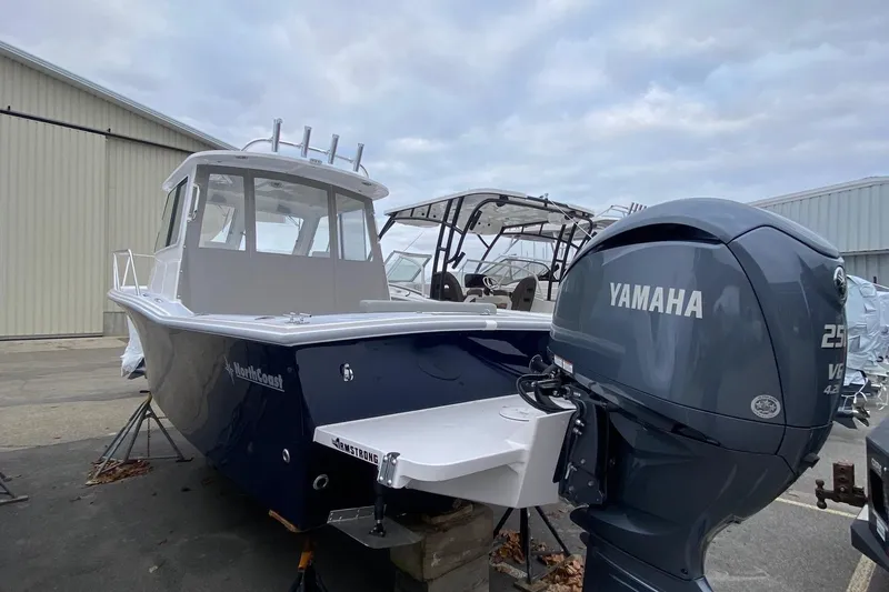 Slide: The Image of 2025 NorthCoast 235 HT boat with Yamaha engine, docked outdoors. - 4
