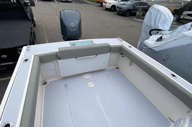 Slide: The Image of 2025 NorthCoast 235 HT boat interior with seating and storage, parked in a lot. - 9