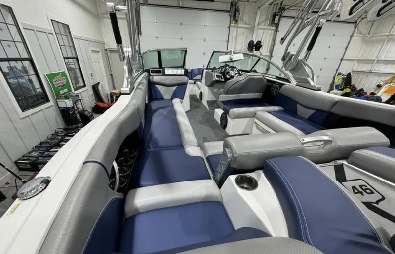 Slide: The Image of 2016 MasterCraft X46 boat interior with blue and gray seating in a garage. - 10