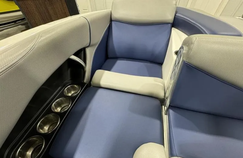 Slide: The Image of 2016 MasterCraft X46 boat interior with blue and gray seating and cup holders. - 12