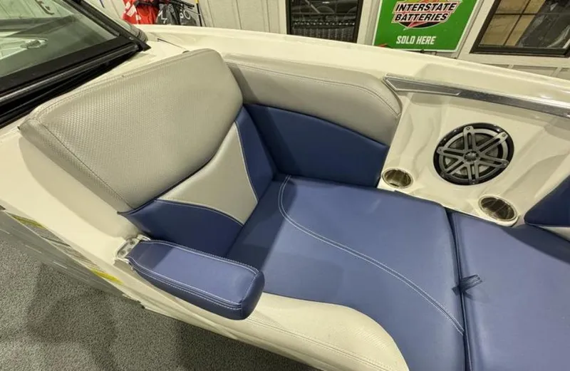 Slide: The Image of 2016 MasterCraft X46 boat interior with blue and gray seating, speaker, and cup holders. - 24