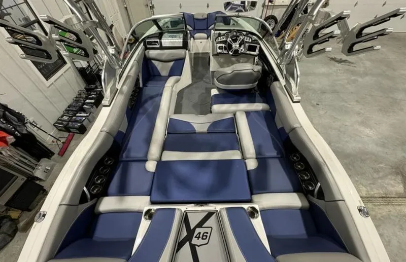 Slide: The Image of 2016 MasterCraft X46 boat interior with blue and gray seating, sleek design, and modern dashboard. - 26