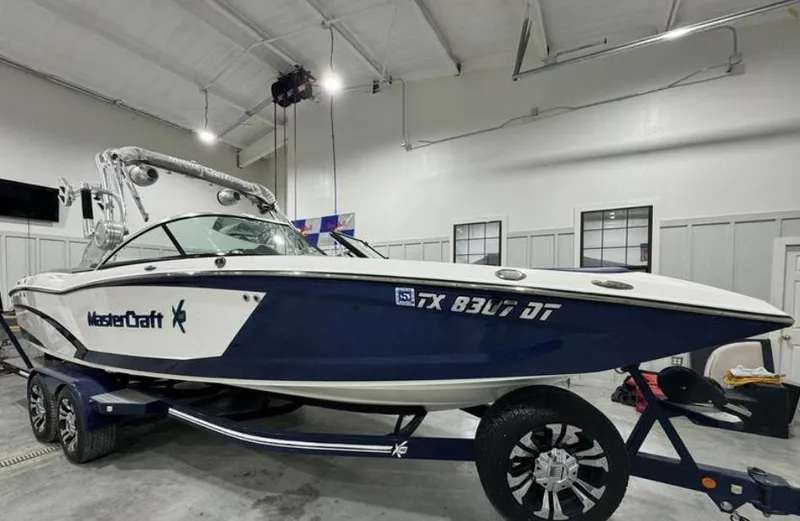 Slide: The Image of 2016 MasterCraft X46 boat in indoor storage, blue and white design. - 6