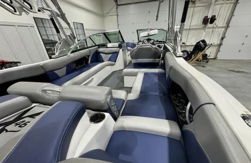 Slide: The Image of 2016 MasterCraft X46 boat interior with blue and gray seating in a garage. - 9