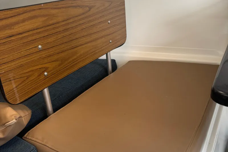 Slide: The Image of Interior of a 2002 MacGregor 26X boat with wood paneling and cushioned seating. - 10