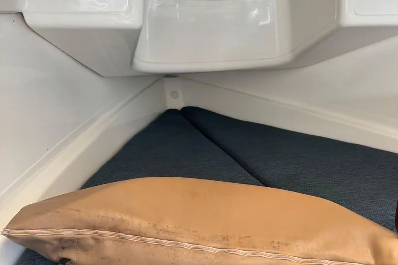 Slide: The Image of Interior cabin of a 2002 MacGregor 26X sailboat with cushions and a tan pillow. - 11