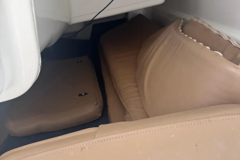 Slide: The Image of Interior cabin view of a 2002 MacGregor 26X sailboat with beige cushions. - 15